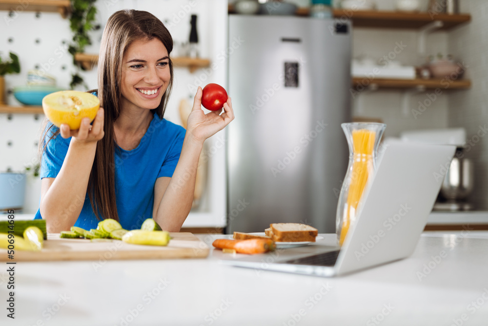 Woman reading recipes over Internet in the kitchen Woman reading recipes over Internet in the kitchen