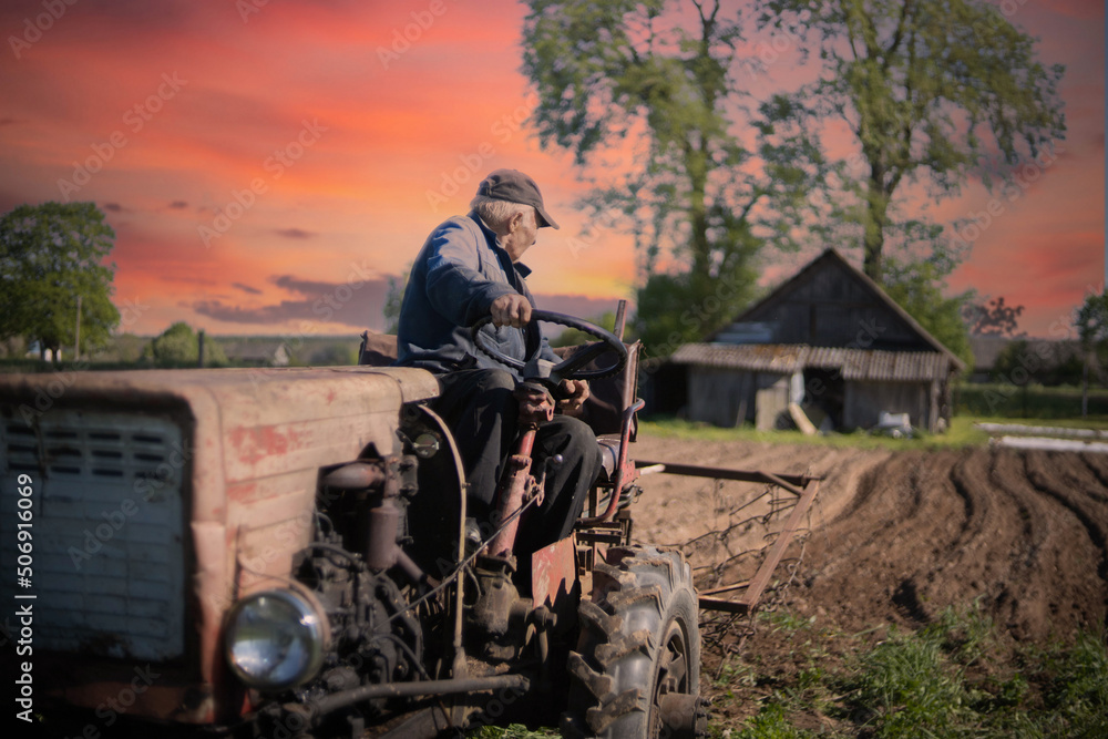 farmer on a tractor plows the soil in the garden, farming in the village. Old vintage tractor. farmer on a tractor plows the soil in the garden, farming in the village. Old vintage tractor.