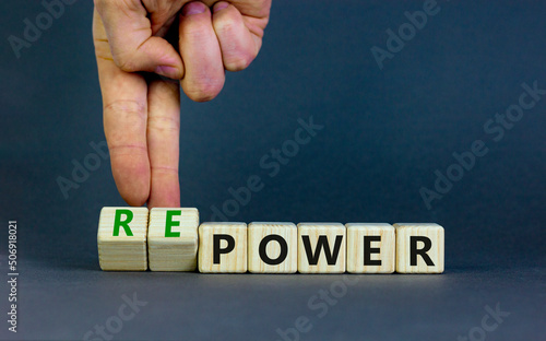 Power or repower symbol. Businessman turns wooden cubes and changes concept words Power to Repower. Beautiful grey table grey background. Business ecological power or repower concept. Copy space.