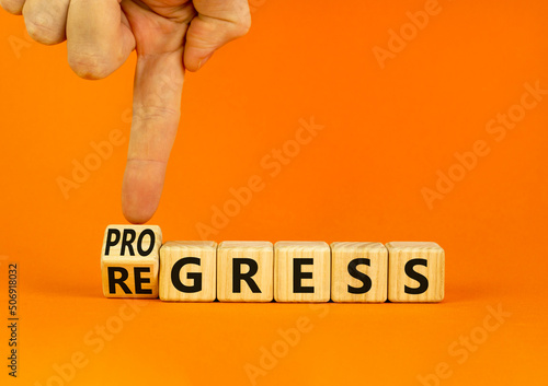 Regress or progress symbol. Businessman turns wooden cubes and changes the word Regress to Progress. Beautiful orange table orange background. Business regress or progress concept. Copy space.