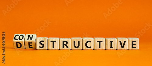 Destructive or constructive symbol. Turned wooden cubes and changed the concept word Destructive to Constructive. Beautiful orange background. Business constructive or destructive concept. Copy space. photo