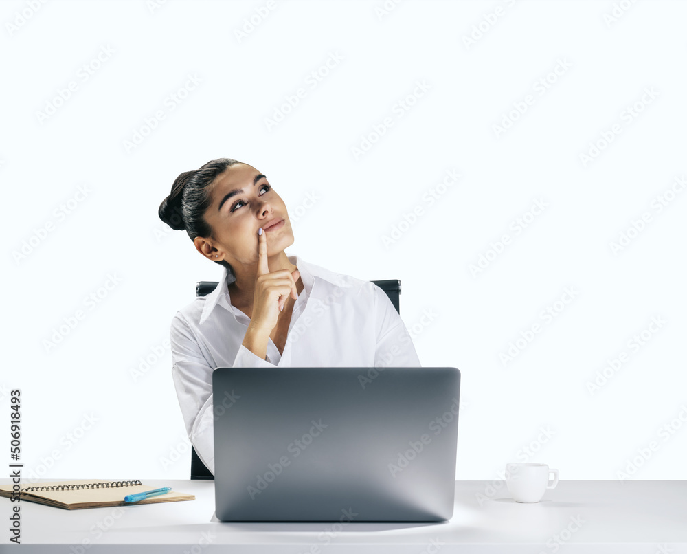 Thinking concept with pensive young woman looking up and trying to find best solution, sitting in front of modern laptop isolated on light wall background, closeup Thinking concept with pensive young woman looking up and trying to find best solution, sitting in front of modern laptop isolated on light wall background, closeup