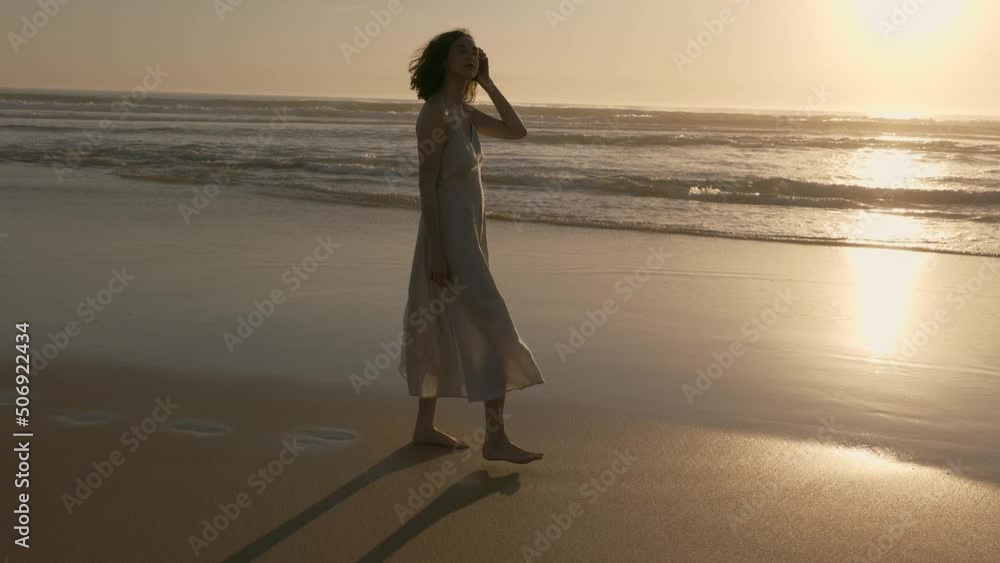 Beautiful young woman of 25 years he walks along the ocean at sunset. Beautiful young woman of 25 years he walks along the ocean at sunset.