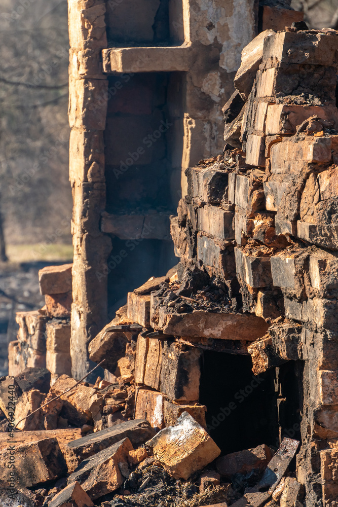 Destroyed houses as a result of a fire in Russia. An old brick rustic stove covered with ash and partially destroyed after a severe fire in a wooden house. Natural disaster