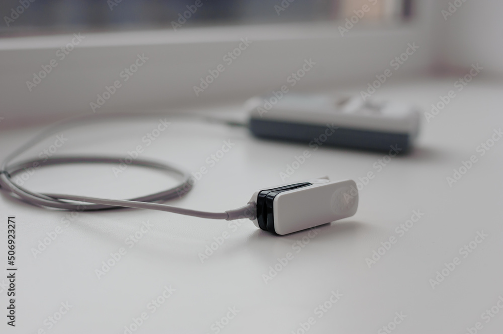 Fototapeta premium Pulse oximeter on a white background. Medical control and diagnostic device for measuring the saturation of capillary blood with oxygen