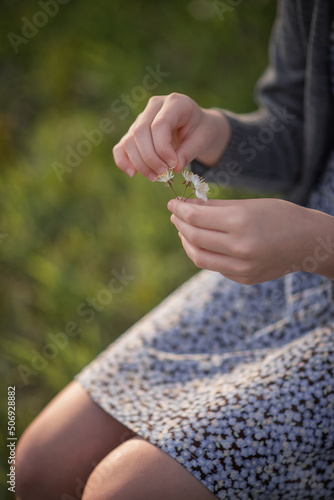 Photo of women's hands with a flower in their hands.