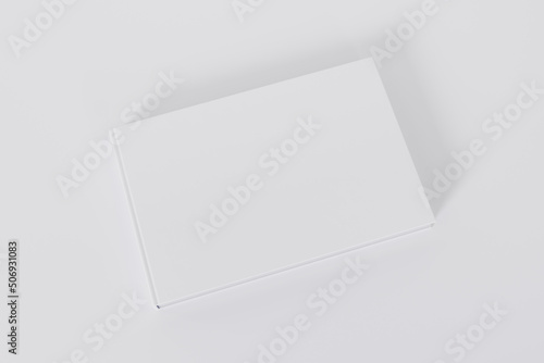 Mockup of a rectangular book with a blank glossy white cover on white background. Isolated with clipping path.	