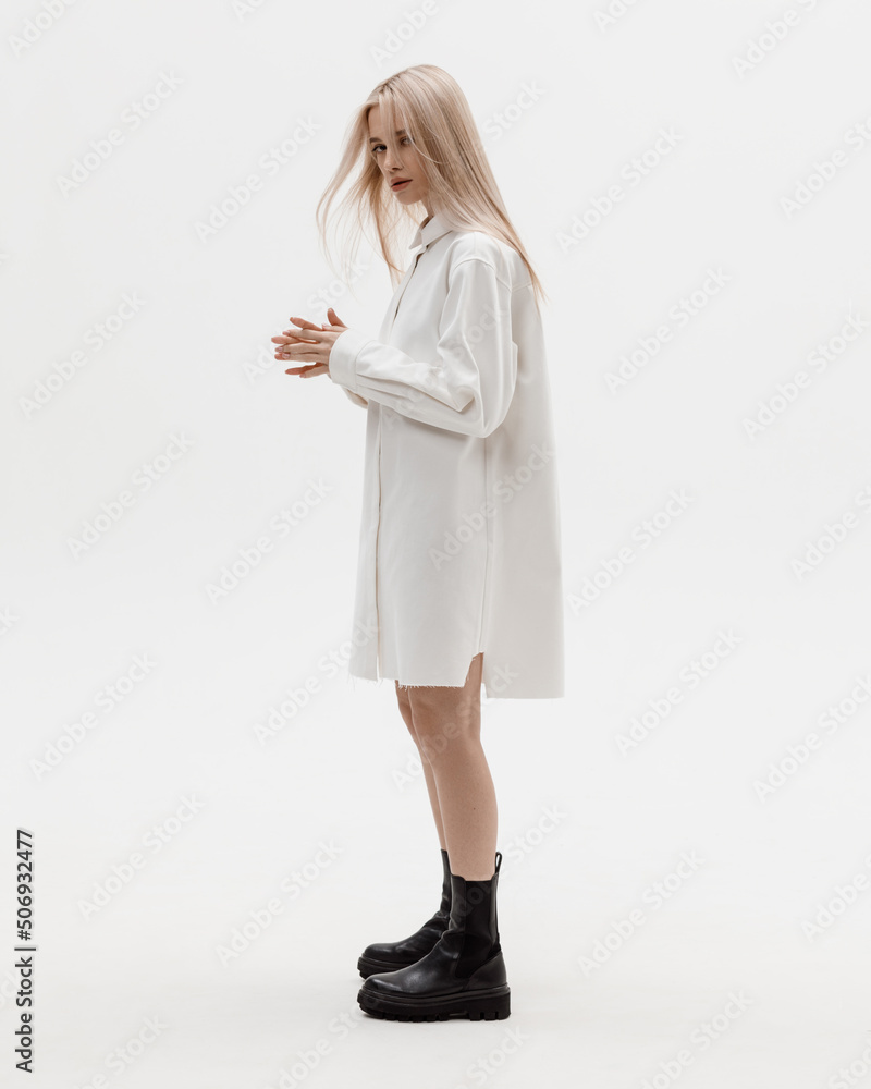 Studio photoshoot of a smiling young blond woman wearing casual clothing against a white background. Natural makeup and hairstyle Studio photoshoot of a smiling young blond woman wearing casual clothing against a white background. Natural makeup and hairstyle