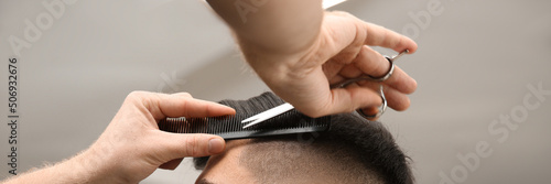 Professional barber making stylish haircut in salon, closeup. Banner design