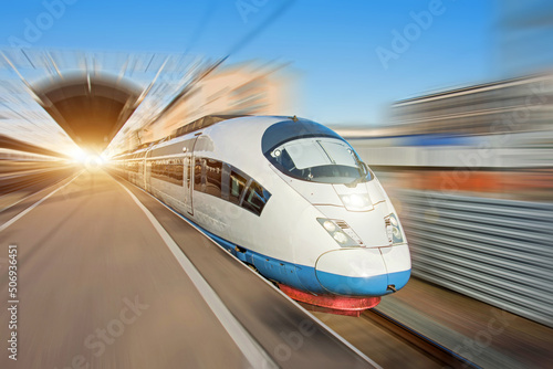 The train departs from the platform of the passenger station, traveling at high speed through the city.