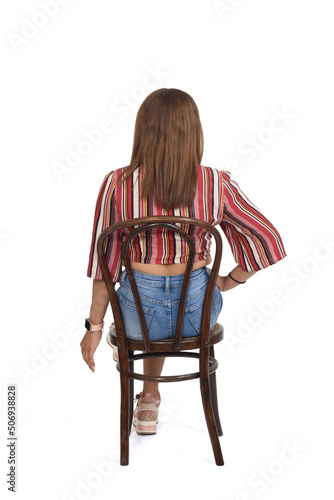 back view of a woman with shorts and sneaker legs crossed background and hand on waist on whiete background photo
