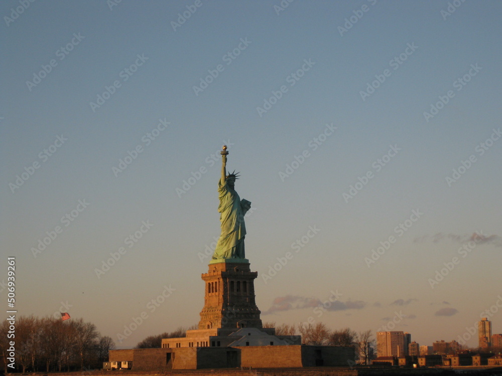 The Statue of Liberty under a clear sky at sunset