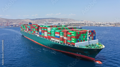 Aerial drone photo of huge container ship leaving logistics and container terminal of Perama, Attica, Greece