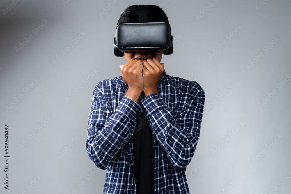 young man using virtual reality showing fear emotion young man using virtual reality showing fear emotion