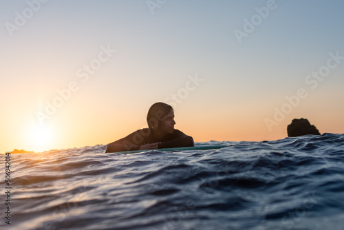 Wallpaper Mural Surfer girl waiting for a wave in the water at sunset Torontodigital.ca