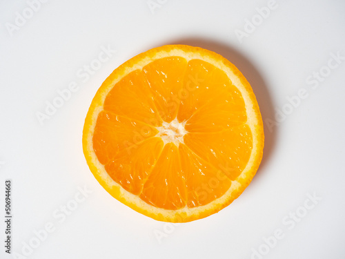 A close-up of an orange cut into slices lies on a white background. Delicious beautiful fruit full of vitamins. Studio shot. top view  flat lay