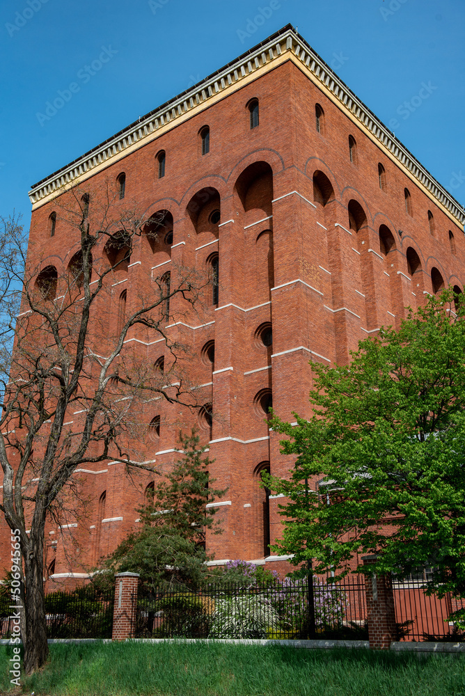 Brick building. Red brick wall of a modern building against a bright blue clear sky on a sunny day. High quality photo