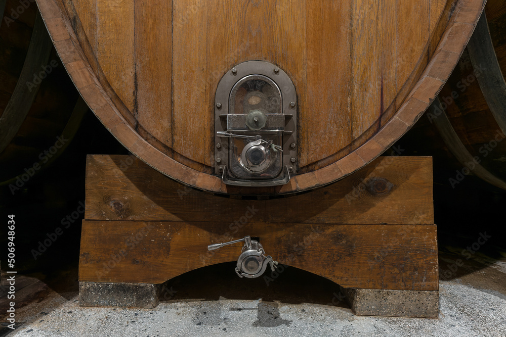 Fototapeta premium Interior of an authentic french wine cellar with old wooden barrels, aging of high quality wine, close-up shot.