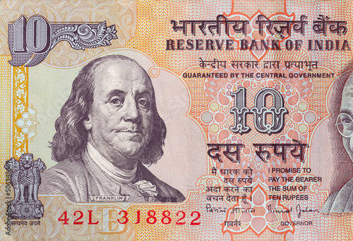 old 10 Indian rupee obverse with superimposed Benjamin Franklin from 100 dollar banknote photo