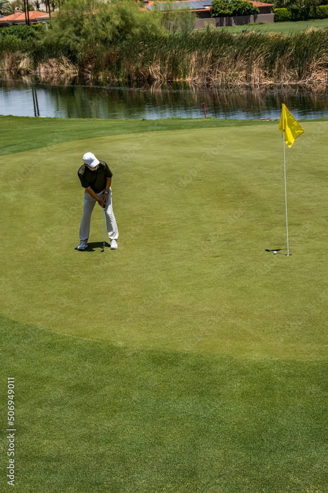Obraz premium Male golfer on profession golf course in a tournament putting on the green