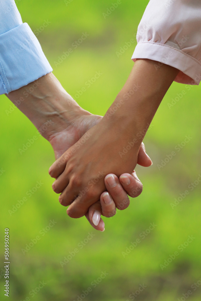 Two women of different ages hold hands. Close-up. Mother and daughter. Two women of different ages hold hands. Close-up. Mother and daughter.