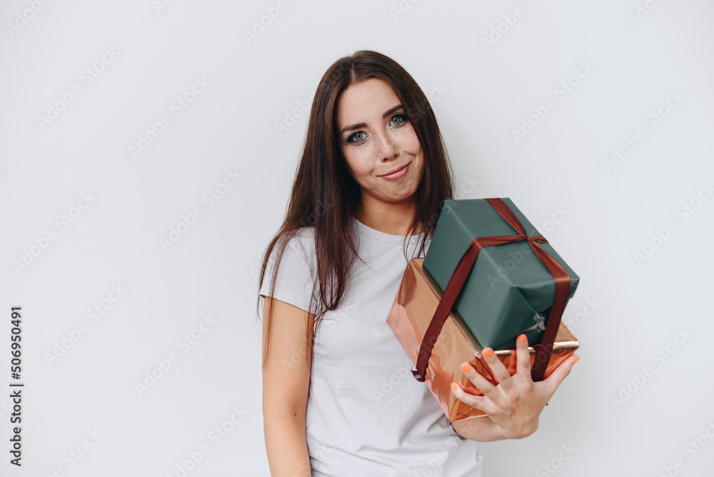 Horizontal photo of a girl who is embarrassed by receiving gifts in the center on a white background Horizontal photo of a girl who is embarrassed by receiving gifts in the center on a white background