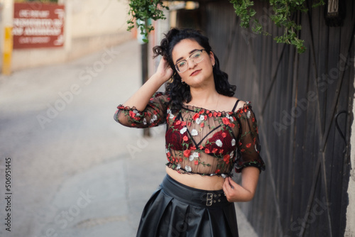 Pretty Latina poses in a see-thru top with a red bra