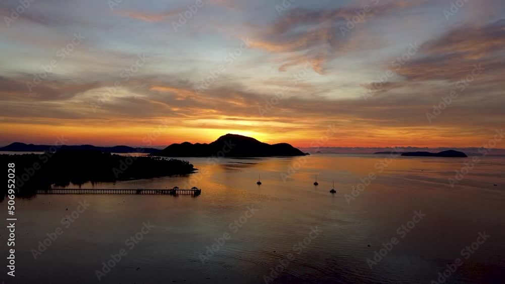 Flight high above the sea towards dawn over tropical islands, orange sunrise in the tropics, drone view Flight high above the sea towards dawn over tropical islands, orange sunrise in the tropics, drone view