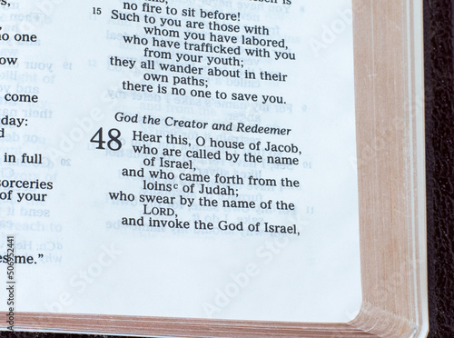 God the Creator and Redeemer verses in an open Holy Bible Book. A close-up. The Christian biblical concept of creation and salvation through Jesus Christ.