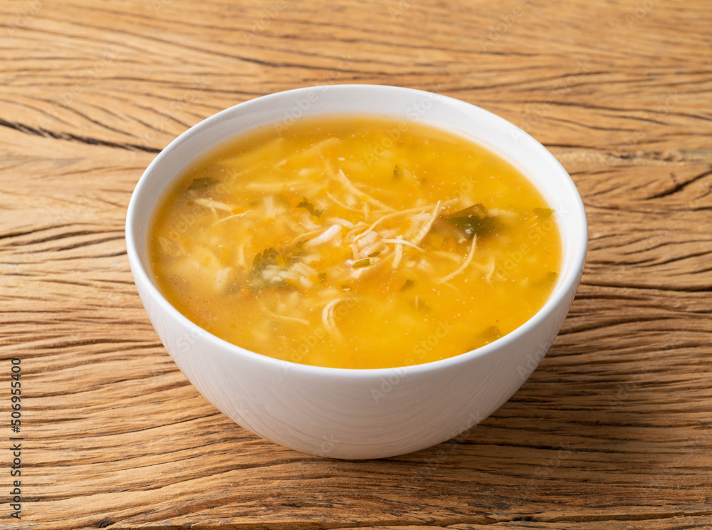 Chicken soup in a bowl over wooden table Chicken soup in a bowl over wooden table