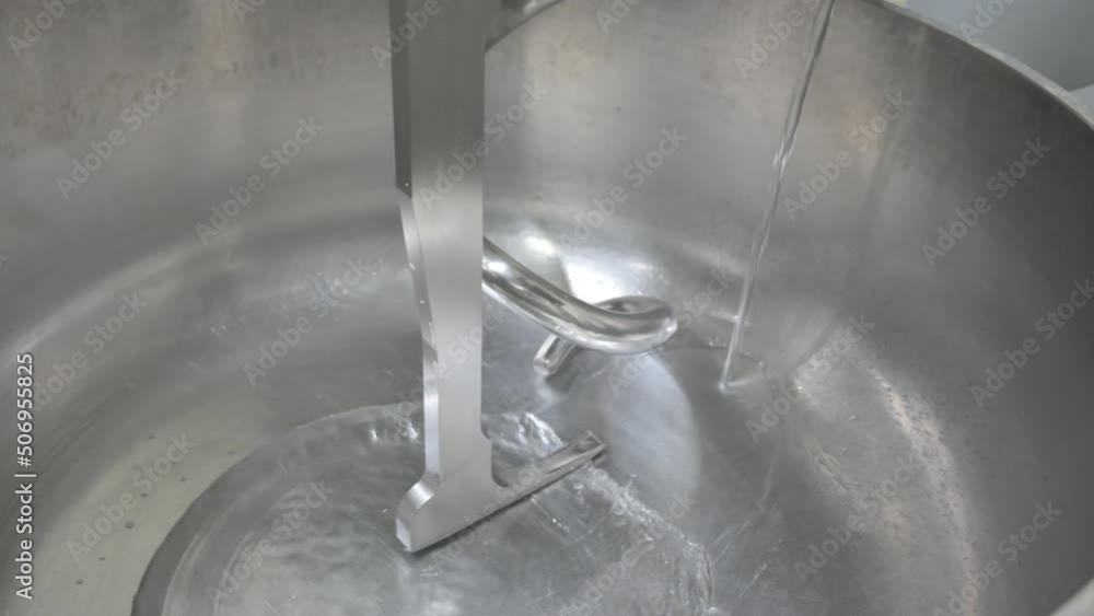 Baker Adding Water to a Professional Kneading Machine. High quality 4k footage Baker Adding Water to a Professional Kneading Machine. High quality 4k footage