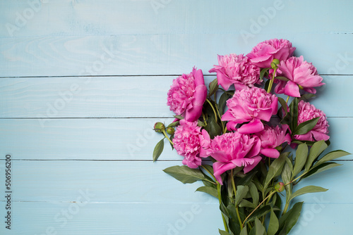 Beautiful pink peony flowers on wooden background  top view