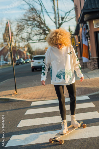 Crazy blon haired multi racial woman on skateboard photo