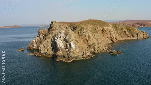 Beautiful island with high vertical rocks among the sea at dawn. Nesting place for seabirds. Untouched nature. Drone view. Klykov Island, Sea of Japan. Vladivostok photo