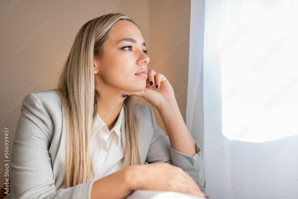 Sad and depressed woman sitting on sofa and looking at distance. Woman bored at home. Sad and depressed woman sitting on sofa and looking at distance. Woman bored at home.