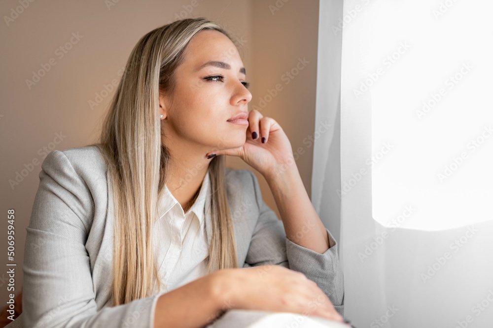 Sad and depressed woman sitting on sofa and looking at distance. Woman bored at home. Sad and depressed woman sitting on sofa and looking at distance. Woman bored at home.
