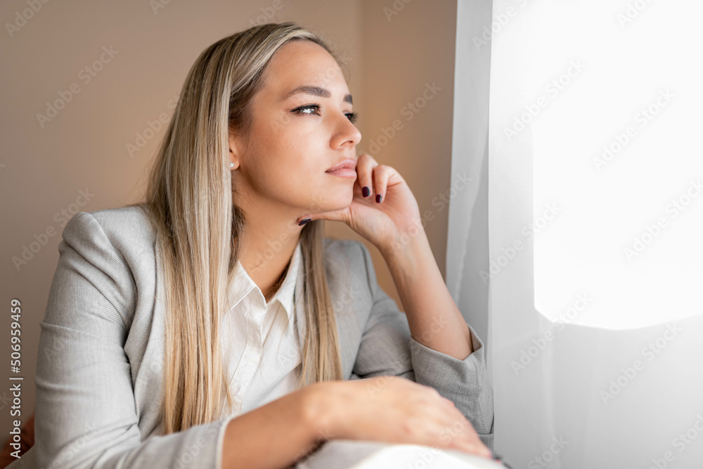 Sad and depressed woman sitting on sofa and looking at distance. Woman bored at home. Sad and depressed woman sitting on sofa and looking at distance. Woman bored at home.