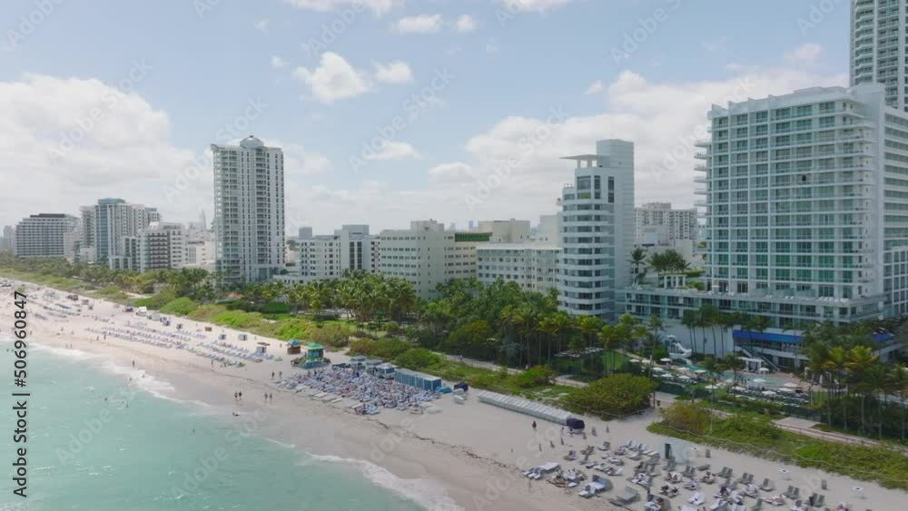 Aerial view of tropical vacation resort. Slide and pan footage of sand beach lined by palm trees and hotels. Miami, USA Aerial view of tropical vacation resort. Slide and pan footage of sand beach lined by palm trees and hotels. Miami, USA