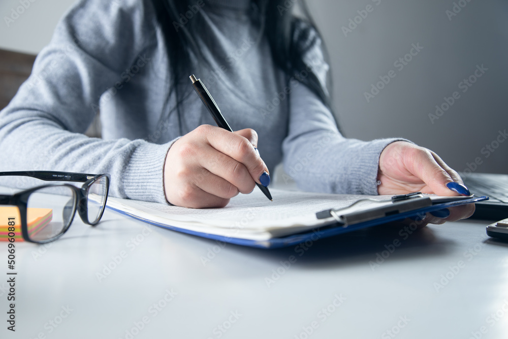 Fototapeta premium Woman signing document and hand holding pen