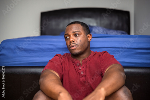 Obraz na płótnie Depressed and anxious African American or black man sitting at home