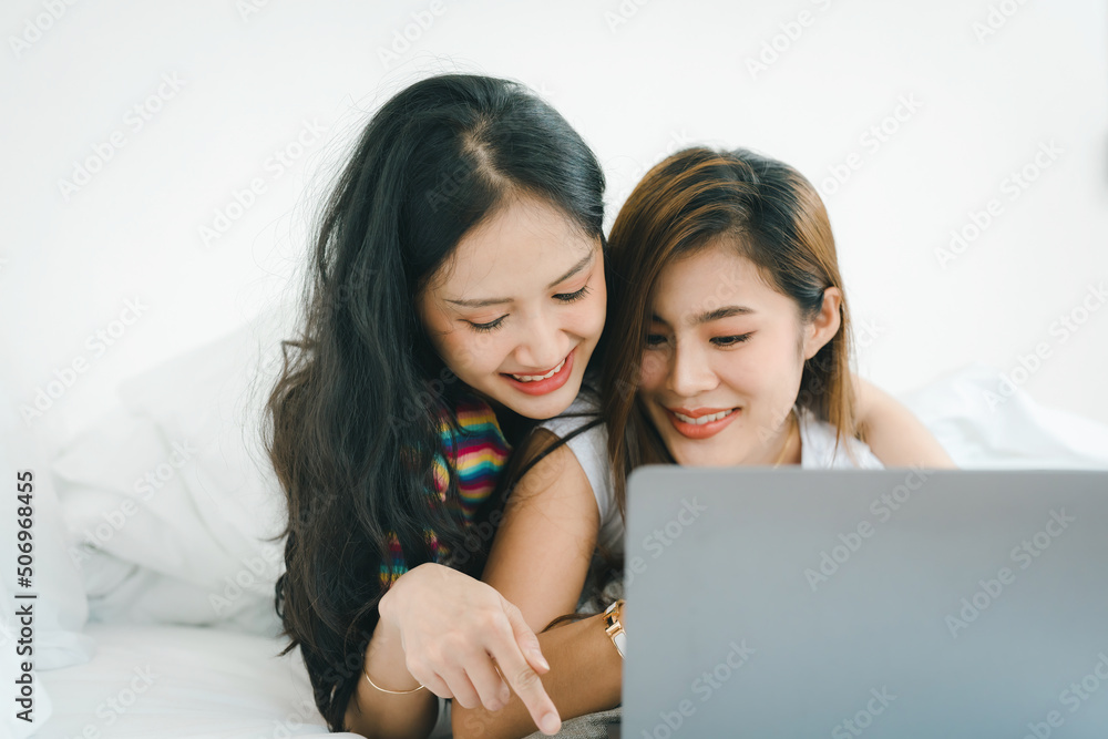 lgbtq, lgbt concept, homosexuality, portrait of two asian women posing happy together and loving each other while playing computer laptop on bed lgbtq, lgbt concept, homosexuality, portrait of two asian women posing happy together and loving each other while playing computer laptop on bed