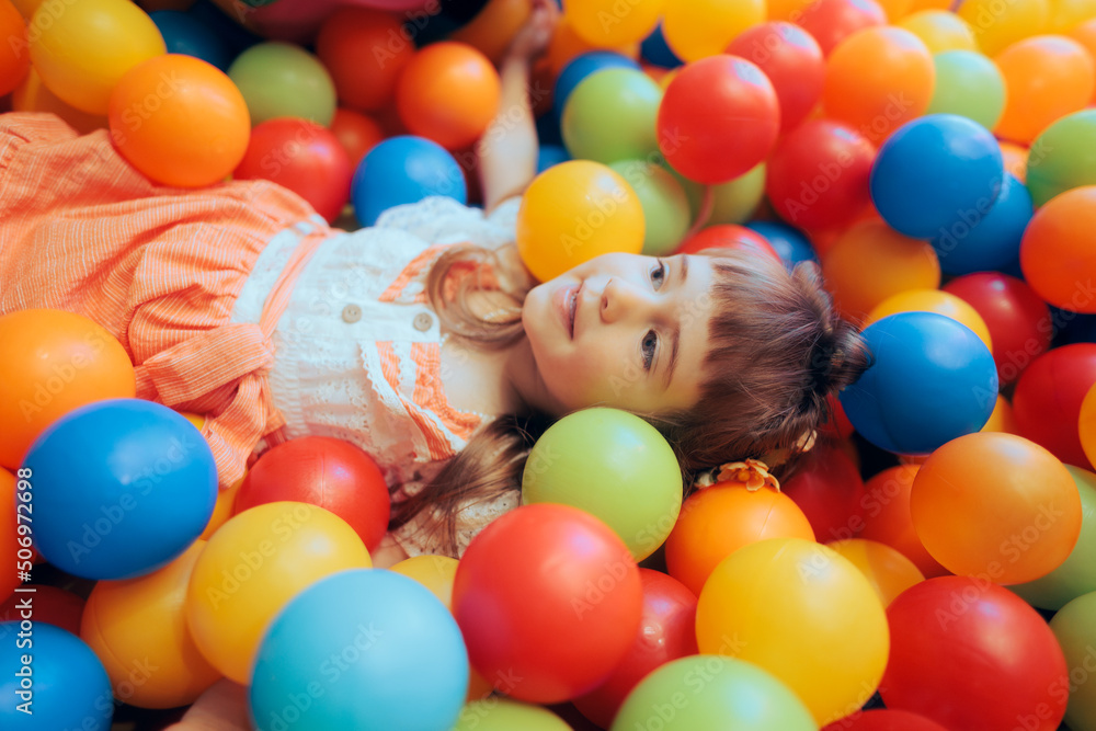 Obraz premium Happy Little Girl Playing in a Ball Pool at a Party
