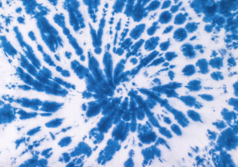 The background of a chaotic pattern in the tie dye style is blue. Flat lay.