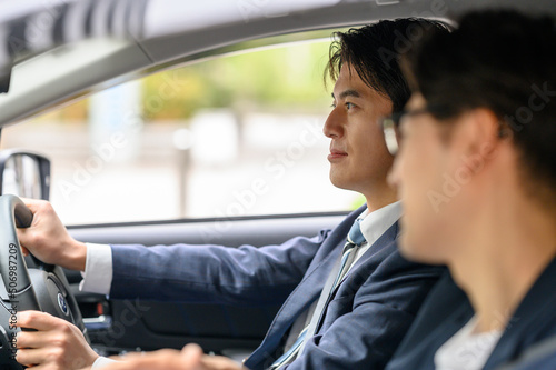車を運転する男性　助手席に乗る男性　 © Peak River