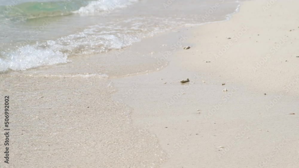 Waves and clear sea water overlooking the sandy bottom. blowing to the shore of the beach amazing white sand beach beautiful on paradise island Waves and clear sea water overlooking the sandy bottom. blowing to the shore of the beach amazing white sand beach beautiful on paradise island