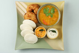  A popular South indian breakfast, Idly Vada sambar or Idli and vada with Sambhar, white coconut and red chutney.