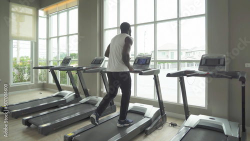 Black African american healthy man, person, running or jogging on treadmill, and training in gym or fitness center in sport and recreation concept. Lifestyle activity.