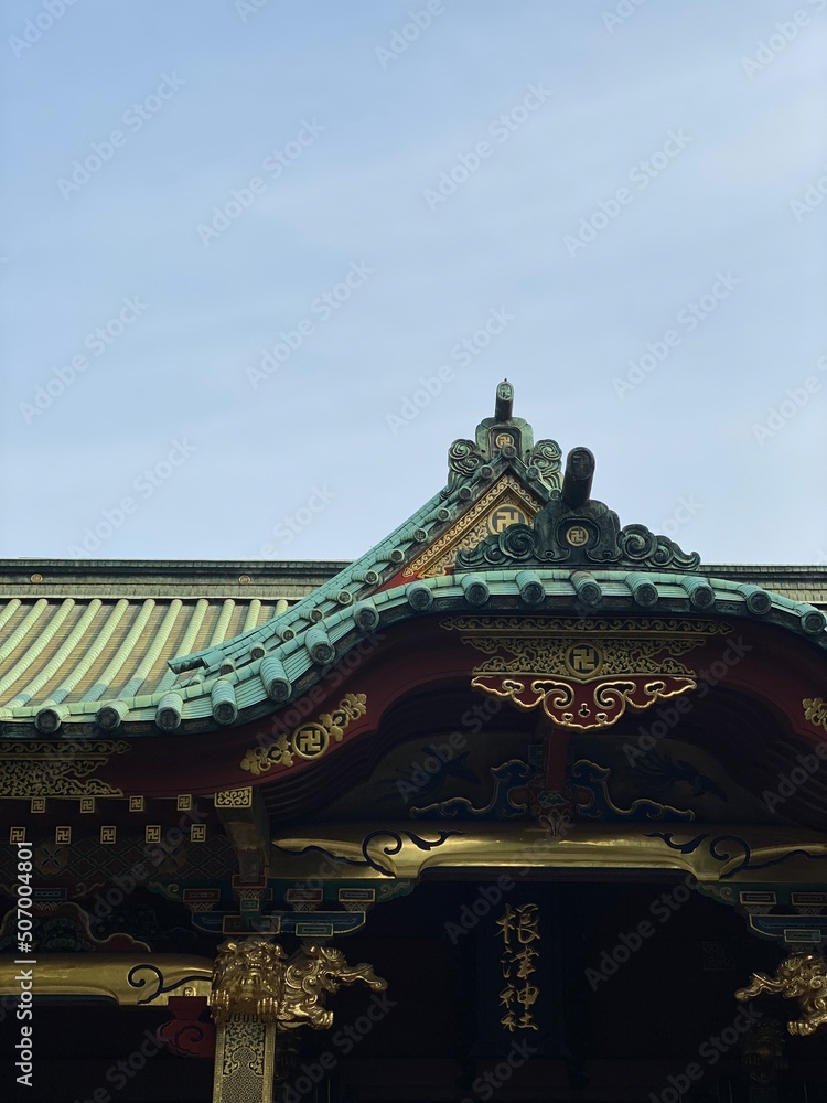 Fototapeta premium The beautiful rooftop detail of the ancient shrine of Japan, “Nezu shrine” year 2022 on a sunny day May 20th, downtown Tokyo Japan