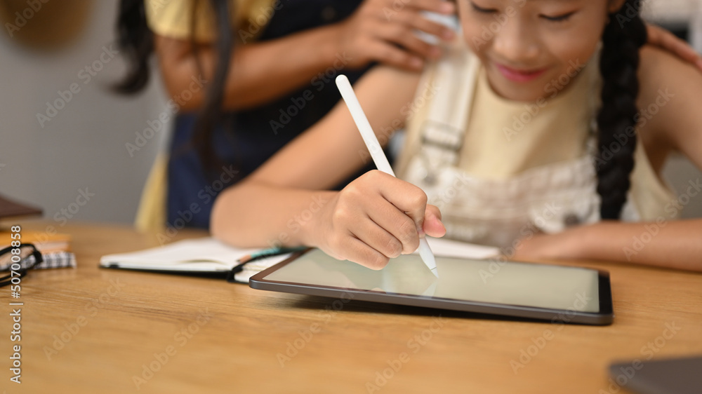 Focused asian girl using digital tablet, doing homework, studying online on web virtual class Focused asian girl using digital tablet, doing homework, studying online on web virtual class