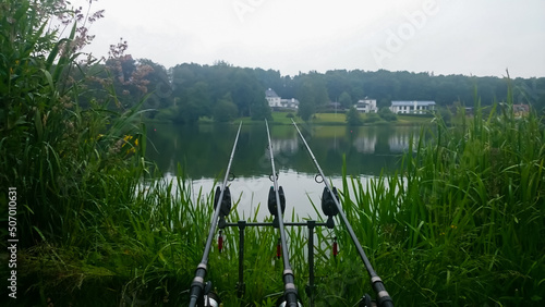 Fishing a large estate lake for Carp through a hole in the reeds. Carp fishing rods and bite alarms. photo